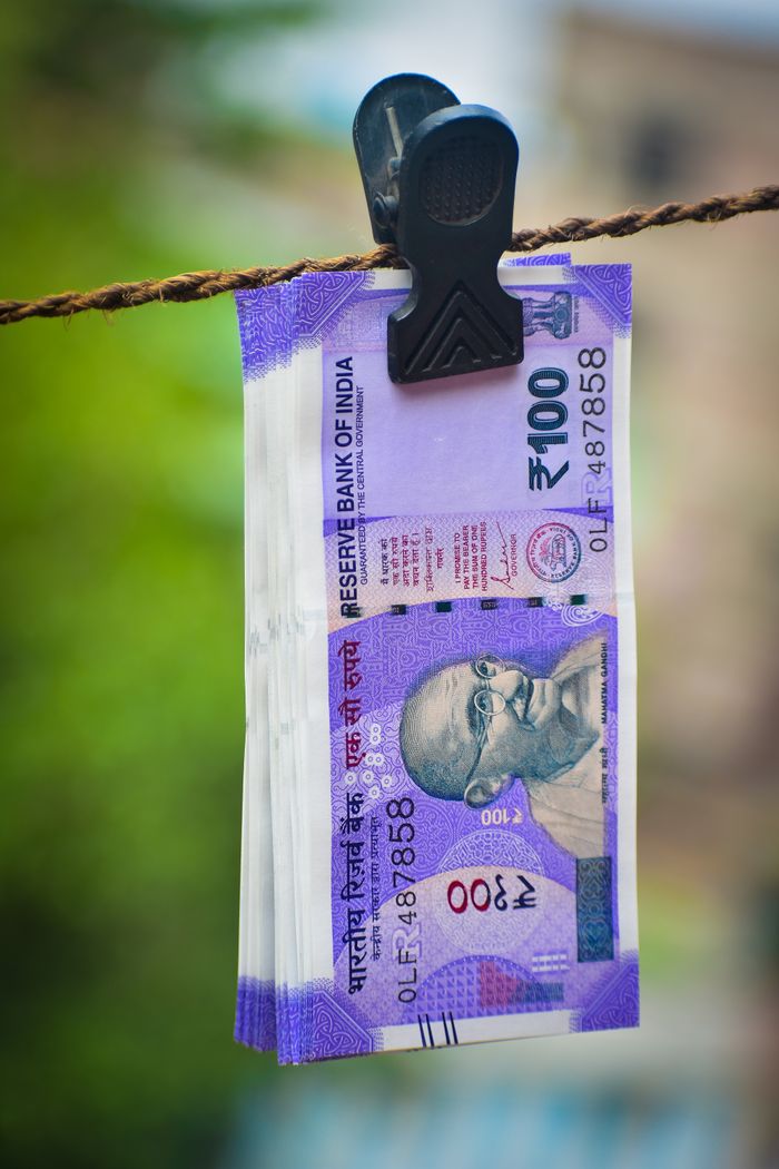 gallery-1 Close-up of Indian 100 rupee notes clipped on a clothesline outdoors in Kolkata, India.